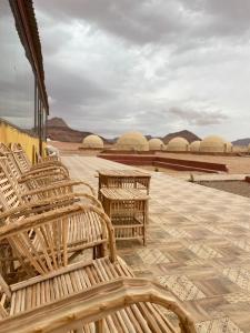 瓦迪拉姆Al Rifi Luxury Camp的庭院里一排木凳,享有沙漠美景