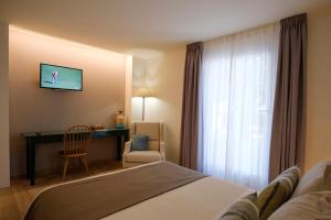 阿瓜阿马加miKasa Agua Amarga & SPA的配有一张床、一张书桌和一扇窗户的酒店客房
