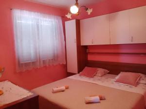 斯维蒂尤拉伊Apartment Drago的宿舍间的两张床,设有红色的墙壁和窗户。