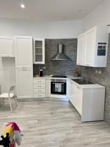 萨莱诺Elvis Home的厨房配有白色橱柜和炉灶烤箱。
