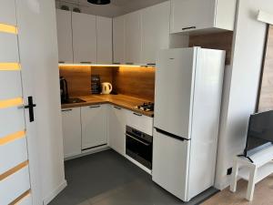 托伦Apartament Zbożowa的厨房配有白色橱柜和白色冰箱。
