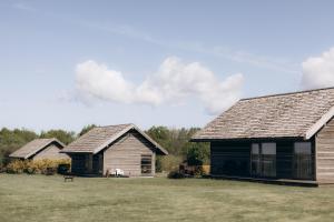 DurbeDurbes Atvari - brīvdienu mājas ar saunu的两栋草场的木屋
