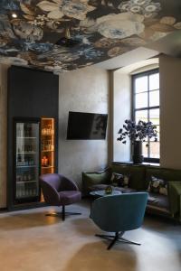 巴特诺因阿尔-阿尔韦勒Boutiquehotel Burg Adenbach & Alter Weinbau的客厅设有天花板和绘画