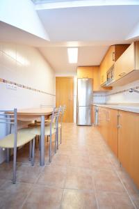 坎巴多斯Céntrico apartamento con parking en Cambados的厨房配有桌椅和冰箱。