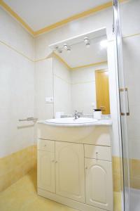 坎巴多斯Céntrico apartamento con parking en Cambados的浴室设有白色水槽和镜子