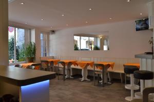 日内瓦圣热尔韦酒店的餐厅设有酒吧,配有橙色椅子和镜子