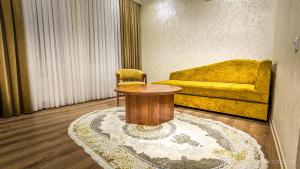 希瓦Hotel Bankir Khiva的客厅配有桌子和黄色沙发