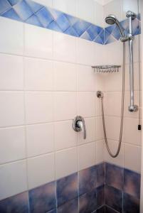 里米尼阿尔德西亚酒店的浴室铺有蓝色和白色瓷砖,设有淋浴。