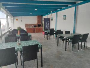 图兹拉Vila La Fernando的一间设有桌椅的用餐室和蓝色的天花板