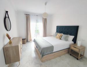 马贝拉La Reserva Beach & Golf Apartment的一间卧室设有一张大床和一个窗户。