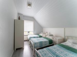 弗利辛恩Comfortable semi-detached holiday home in Vlissingen的一间卧室设有三张床和窗户。