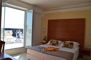 里米尼德尔帕可别墅酒店的一间带大床的卧室和一个阳台