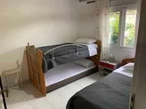 KondárainaKONTI VILLA的一间卧室设有两张双层床和一扇窗户。