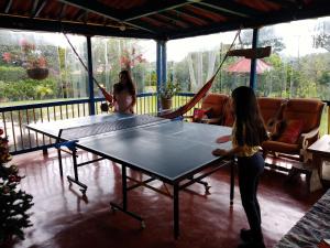 锡卡西亚Finca El Topacio Circasia-Quindio的两个女人在桌上打乒乓球