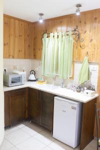 Amnonצימר בלוטים באמנון的厨房配有木制橱柜和白色冰箱。