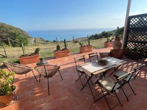 雷阿尔蒙特B&B La Torre的一个带桌椅的庭院和大海