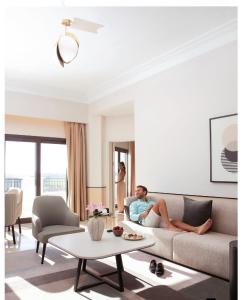 阿莱曼Address Marassi Golf Resort Hotel Appartments的坐在客厅沙发上的男人