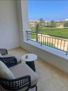 阿莱曼Address Marassi Golf Resort Hotel Appartments的客房设有带椅子和桌子的阳台。