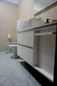 里米尼A CASA CAVOUR RIMINI CENTER accanto al Teatro Galli的白色的浴室设有水槽和卫生间。