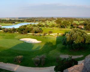 圣玛格利特迪普拉Villa Bellavista IS MOLAS PULA, CAGLIARI的享有高尔夫球场空中美景,设有池塘