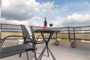 斯巴达Z5 Sky Sparta Apartment的坐在阳台上的桌子上,喝一杯葡萄酒