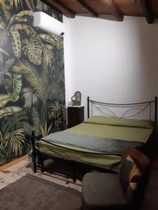 卡尔塔尼塞塔La casa dell' Agave的一间卧室配有一张床和一张带壁画的椅子
