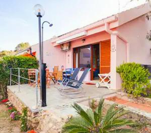 圣玛格利特迪普拉Villa Bellavista IS MOLAS PULA, CAGLIARI的房屋设有带椅子和灯的庭院
