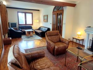 萨拉热窝Vila Gardenia的客厅配有皮革家具和壁炉