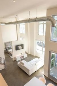 洛杉矶1500 Sq foot, 3 bed room loft in DTLA (Pool & Hot tub!)的客厅配有白色沙发和电视