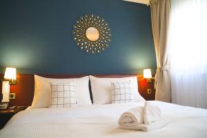 洛桑洛桑郁金香酒店的卧室配有白色的床和毛巾