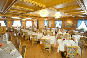 帕索圣佩莱格里诺圣马可酒店的一间设有白色桌椅的用餐室