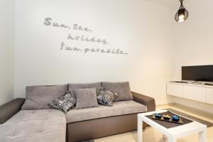 克尔克Villa Palma Krk的客厅配有一张沙发,墙上有一句名言