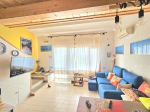 圣玛格利特迪普拉Villa Bellavista IS MOLAS PULA, CAGLIARI的客厅配有蓝色的沙发和电视