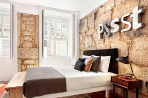 波尔图波尔图雅致舒适一室公寓酒店的一间卧室设有一张床和砖墙
