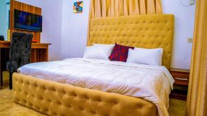 阿沙巴KUNN Apartments的一张大床,在房间内有一个黄色的大床头板