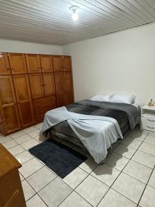 乌鲁比西Casa Recanto Alegria的卧室配有1张床,铺有瓷砖地板。