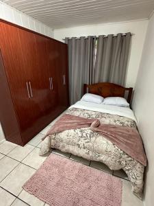乌鲁比西Casa Recanto Alegria的一间卧室配有床、橱柜和地毯