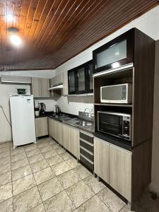 乌鲁比西Casa Recanto Alegria的厨房配有白色冰箱和微波炉