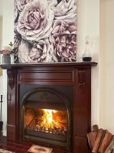 麦克拉伦谷红酒玫瑰住宿加早餐旅馆的客厅的壁炉,上面有画作