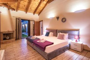 扎金索斯镇Astarte Villas - Kyveli Luxurious Private Villa的一间卧室设有一张大床和一个壁炉