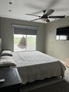 蒙特雷Residencia en Apodaca Nuevo León的一间卧室配有一张带吊扇和窗户的床。