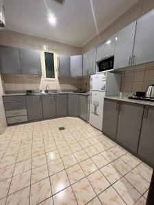 利雅德سمو سويت للشقق المخدومة 2 Smo Suites的一间厨房,配有白色家电,铺有瓷砖地板