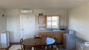 努库阿洛法Sky Lodge的厨房配有桌椅和冰箱。