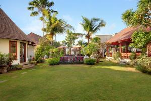 乌鲁瓦图巴里坎达西尔酒店的棕榈树庭院和房屋