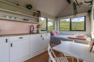 TooboracHeathcote Valley Tiny House - Tiny Stays的一间小房子,设有厨房、一张床和一张桌子