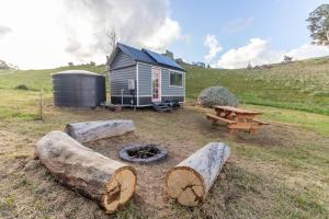 TooboracHeathcote Valley Tiny House - Tiny Stays的一个小房子,一张野餐桌和一个火坑