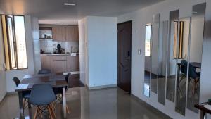 里奥阿查RH03 Riohacha apartamento perfecto para trabajar o vacacionar frente a la playa的厨房以及带桌椅的用餐室。