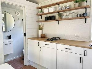 雷德山Mornington Peninsula Tiny House - Tiny Stays的厨房配有白色橱柜和镜子