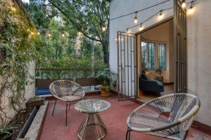 墨西哥城Unique Roma Apartments S51 By MrW的庭院配有两把椅子和一张桌子