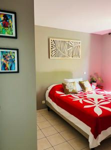 AtiueVahinerii Cosy Apt Tahiti的一间卧室配有一张带红白毯子的床